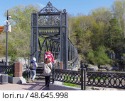 Туристки заходят на пешеходный мост через реку Белую в Белорецке, Башкирия, Россия. Редакционное фото, фотограф Алексей Иванов / Фотобанк Лори
