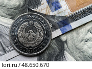 Close-up of Uzbekistan som coin on US 100 dollar bills in focus. Стоковое фото, фотограф Емельянов Евгений Викторович / Фотобанк Лори