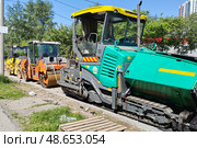Асфальтоукладчик и каток, на месте проведения дорожных работ (2024 год). Редакционное фото, фотограф Vladislav_v / Фотобанк Лори