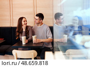 Couple enjoying coffee and conversation at a cozy cafe in the afternoon. Стоковое фото, фотограф Сергей Толмачёв / Фотобанк Лори