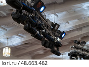 Advanced lighting fixtures are strategically arranged above a spacious venue, showcasing a sophisticated setup for an upcoming event. Стоковое фото, фотограф Данила Большаков / Фотобанк Лори