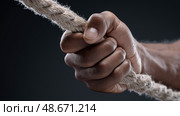Strong hand gripping a thick rope in a dramatic black and white composition. Сильная рука держит толстый канат в драматической  композиции. Стоковое AI-изображение, AI-художник Katsiaryna Repich / Фотобанк Лори