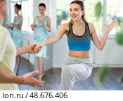 Couple in comfortable sports clothes learns boogie woogie dancing during individual lesson. Стоковое фото, фотограф Яков Филимонов / Фотобанк Лори