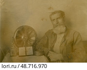 Пожилой мужчина с бородой сидит у радиоприёмника. Стоковое фото, фотограф Retro / Фотобанк Лори