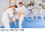 Pairs classes in judo or jiu jitsu - two teenage girls practice grabbing and throwing on sports mats. Стоковое фото, фотограф Яков Филимонов / Фотобанк Лори