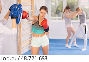 Girl teenager with her trainer in gym learns to hit punch mitts. Стоковое фото, фотограф Яков Филимонов / Фотобанк Лори