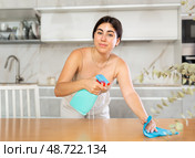 Positive young woman cleaning the surface of kitchen table. Стоковое фото, фотограф Яков Филимонов / Фотобанк Лори
