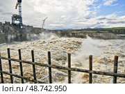 Бурлящая вода, прошедшая сквозь плотину гидроэлектростанции ( сквозь водоводы ) при строительстве Усть-Среднеканской ГЭС на Колыме (2012 год). Редакционное фото, фотограф Павел Просянов / Фотобанк Лори