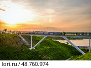 Пешеходный мост над оврагом на фоне заката в городе. Редакционное фото, фотограф Илья Старков / Фотобанк Лори