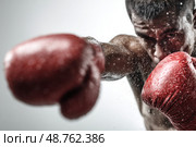 A man is boxing with his red gloves on. Стоковое AI-изображение, AI-художник Ярославский Максим / Фотобанк Лори