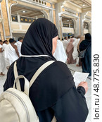 A female pilgrim with a prayer in her hands makes the traditional procession between Safa and Marwa in the Sacred Mosque of Al-Haram. Стоковое фото, фотограф Луиза Налимова / Фотобанк Лори