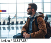 Мужчина в аэропорту ждет вылета. Стоковое AI-изображение, AI-художник Boostport / Фотобанк Лори