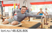 Man performs exercise on reformer to improve coordination, balance, and posture. Стоковое фото, фотограф Яков Филимонов / Фотобанк Лори