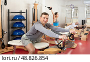 Man during Pilates training performs exercises and tasks on heron pulley tower. Стоковое фото, фотограф Яков Филимонов / Фотобанк Лори