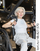 Elderly woman training on chest press machine in gym. Стоковое фото, фотограф Яков Филимонов / Фотобанк Лори