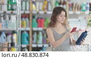 Girl buyer scans qr code on tile cleaner spay label. Стоковое видео, видеограф Яков Филимонов / Фотобанк Лори