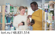 Woman with African man sniffs fragrance of perfume, chooses scent spray with pleasant smell. Стоковое видео, видеограф Яков Филимонов / Фотобанк Лори