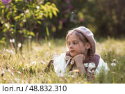 Vintage women's accessories and retro-style clothing. A small, beautiful girl with bows in her hair, in a beige dress and a beret outdoors. Стоковое фото, фотограф Photojuli / Фотобанк Лори
