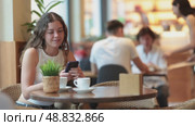 Young woman with phone in cafe. Стоковое видео, видеограф Яков Филимонов / Фотобанк Лори