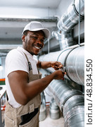 Skilled worker performs maintenance on industrial piping in a modern facility. Стоковое фото, фотограф Сергей Толмачёв / Фотобанк Лори