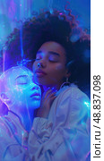 A young woman with curly hair embraces a digital entity with glowing blue lines on its face. The image is bathed in a soft blue light. Стоковое AI-изображение, AI-художник Данила Большаков / Фотобанк Лори
