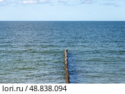 Seaside view featuring a wooden groyne extending into the ocean. Стоковое фото, фотограф EugeneSergeev / Фотобанк Лори