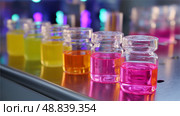 Colorful liquid samples arranged on a laboratory countertop showcasing diverse chemical solutions during a scientific experiment. Стоковое AI-изображение, AI-художник Сергей Толмачёв / Фотобанк Лори