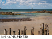 View of the coast of the city with wooden breakwaters in the foreground at low tide on a sunny summer day, Saint-Malo, Brittany, France. Стоковое фото, фотограф Ula Ulachka / Фотобанк Лори