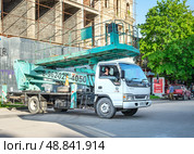 Автогидроподъёмник  Isuzu Elf возле строительного объекта. Редакционное фото, фотограф Лариса Веселова / Фотобанк Лори