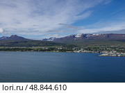 Вид на Акюрейри (Akureyri) с восточного берега Эйяфьордура (Eyjafjordur ) в Исландии - Эйяфьордур является самым длинным фьордом в Исландии. Он расположен в центральной части северной части страны. Стоковое фото, фотограф Дымов Игорь / Фотобанк Лори