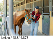 Young woman leads horse out of stable. Стоковое фото, фотограф Яков Филимонов / Фотобанк Лори