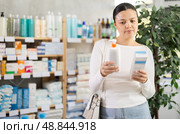 Middle-aged woman choosing cream in drugstore. Стоковое фото, фотограф Яков Филимонов / Фотобанк Лори