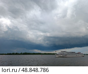 Теплоход на реке на фоне грозовой тучи. Редакционное фото, фотограф Наталия Ануфриева / Фотобанк Лори