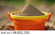 Colorful children toy bucket with sand stands in sandbox. AI Generative. Стоковое AI-видео, аниматор Spirit River / Фотобанк Лори