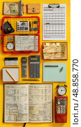 A flat lay image of various office supplies on a yellow background, including calculators, spreadsheets, notebooks, and a pencil. Стоковое AI-изображение, AI-художник Данила Большаков / Фотобанк Лори