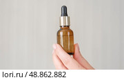 Female hands showing natural oil cosmetics on a Beige Background. Dropper amber brown glass Bottle with pipette. Spa Beauty products Isolate on Neutral Backdrop. Skincare recommend, makeup advertising. Стоковое видео, видеограф Марина Демидюк / Фотобанк Лори