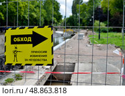 Предупреждающая табличка на строительном объекте  с указателем: «Обход. Приносим извинения за  неудобства” (2019 год). Редакционное фото, фотограф Snezka / Фотобанк Лори