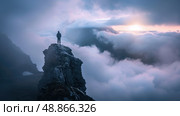 A single person stands on a rocky clifftop, overlooking a vast expanse of clouds at sunset. The light from the setting sun illuminates the clouds, creating a dramatic and beautiful scene. Стоковое AI-изображение, AI-художник Данила Большаков / Фотобанк Лори