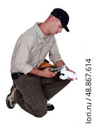Plumber  kneeling. Стоковое фото, агентство Ingram Publishing / Фотобанк Лори