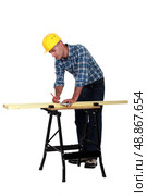 Carpenter measuring wood lath. Стоковое фото, агентство Ingram Publishing / Фотобанк Лори