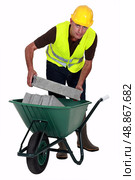 Mason carrying bricks in wheel barrow. Стоковое фото, агентство Ingram Publishing / Фотобанк Лори
