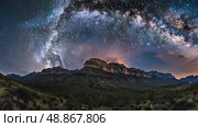 Experience a breathtaking night sky filled with stars and the Milky Way arching over a serene mountainous terrain in a remote area. Стоковое AI-видео, аниматор Данила Большаков / Фотобанк Лори