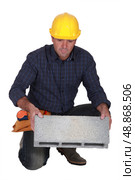 Tradesman holding a clinker block. Стоковое фото, агентство Ingram Publishing / Фотобанк Лори