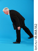 Old businessman struggling to stay in his feet. Стоковое фото, агентство Ingram Publishing / Фотобанк Лори