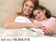 Mother and daughter in bed together. Стоковое фото, агентство Ingram Publishing / Фотобанк Лори