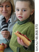 Little girl eating sandwich with mother. Стоковое фото, агентство Ingram Publishing / Фотобанк Лори
