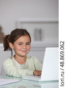 Little girl sat with laptop. Стоковое фото, агентство Ingram Publishing / Фотобанк Лори