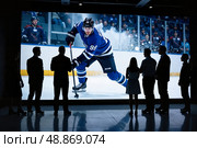 Группа людей смотрит на хоккей на большом экране с копи-спейсом. / Group of people watching a hockey player on a large screen with copy space. Стоковое AI-изображение, AI-художник Валерий Лукин / Фотобанк Лори