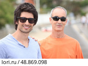 Two men of different generations wearing sunglasses and t-shirts. Стоковое фото, агентство Ingram Publishing / Фотобанк Лори