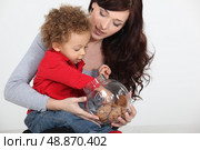 Little boy grabbing biscuit from jar. Стоковое фото, агентство Ingram Publishing / Фотобанк Лори